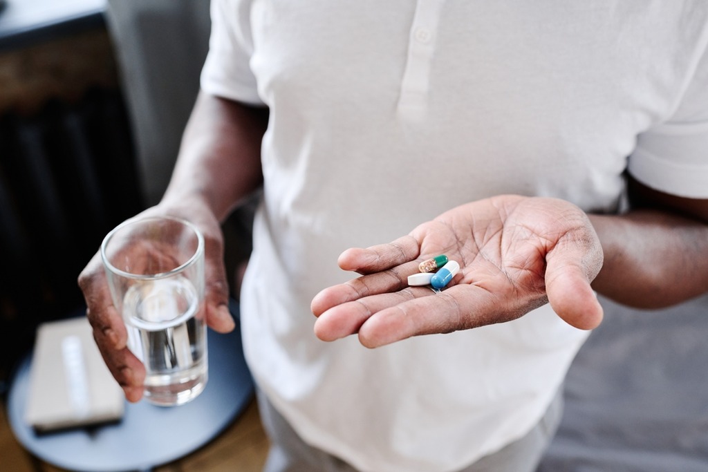 Paciente segurando medicamentos usados no tratamento do herpes zoster.